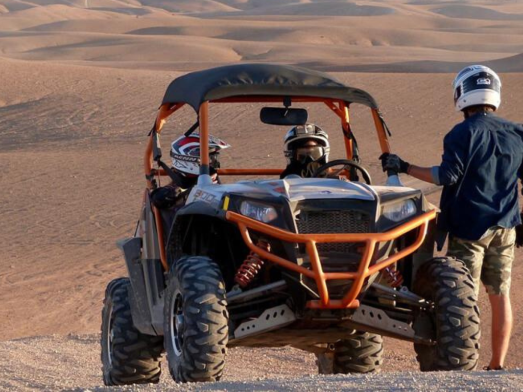 Niños sonrientes montando en camello por las dunas del desierto de Merzouga
