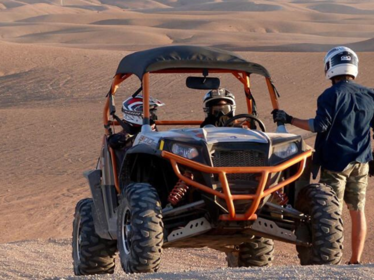 Niños sonrientes montando en camello por las dunas del desierto de Merzouga