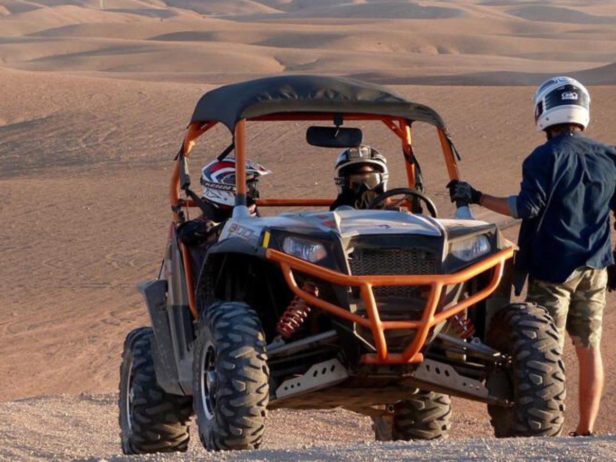 Niños sonrientes montando en camello por las dunas del desierto de Merzouga